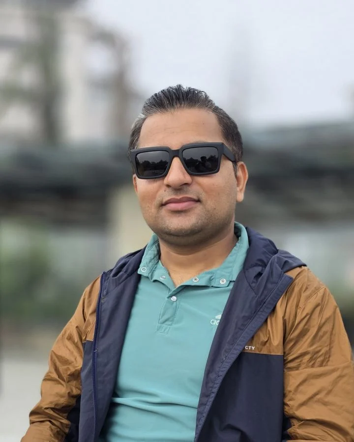Ramesh Gautam, senior frontend developer, smiling in sunglasses and a brown and navy jacket